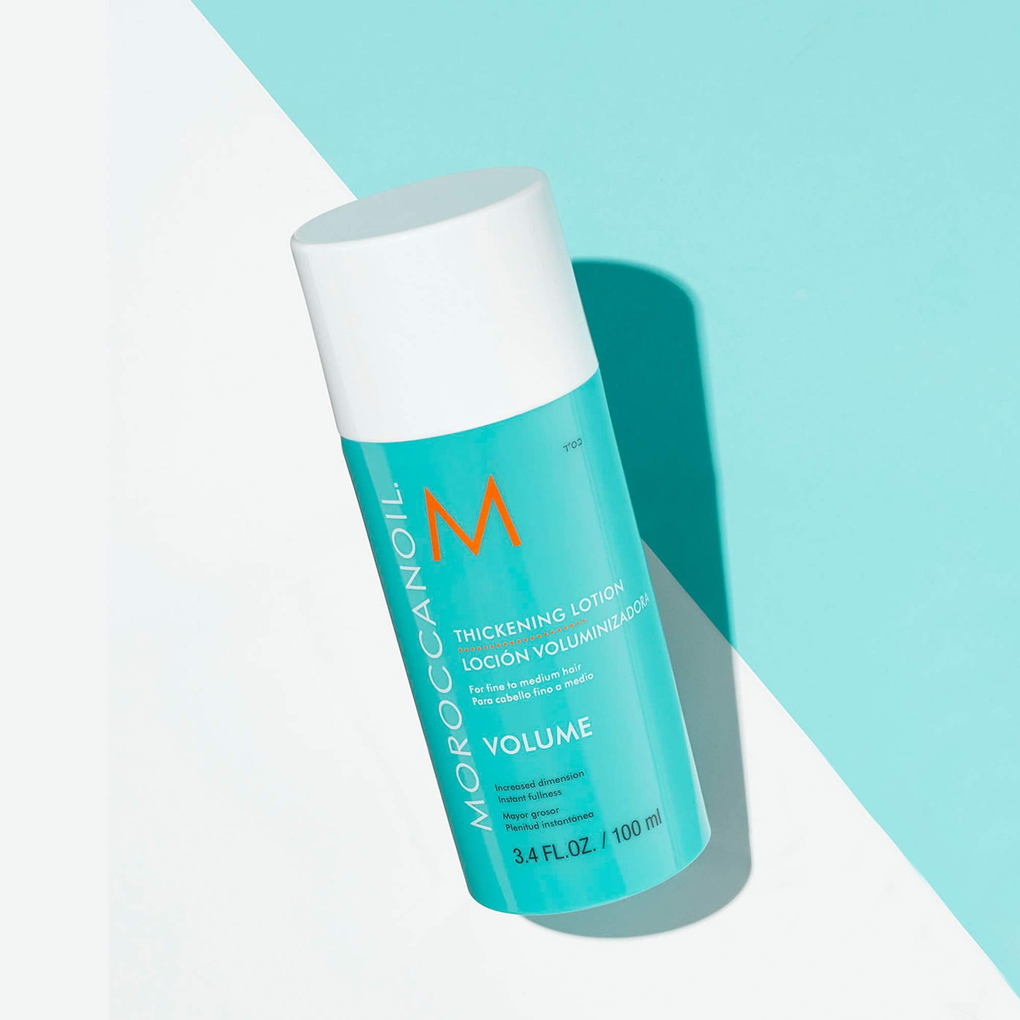 Moroccanoil Thickening Lotion 3.4 oz for volumizing hair, enriched with argan oil, shown in a clear bottle with a pump dispenser.