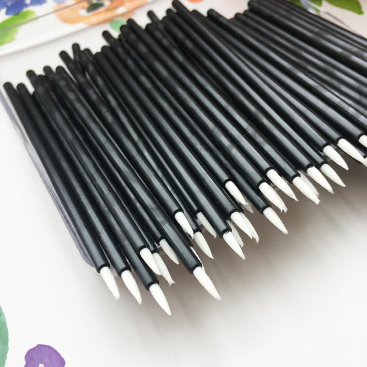 Set of 100 WOFASHPURET disposable eyeliner brushes with thin nylon tips for precise makeup application.