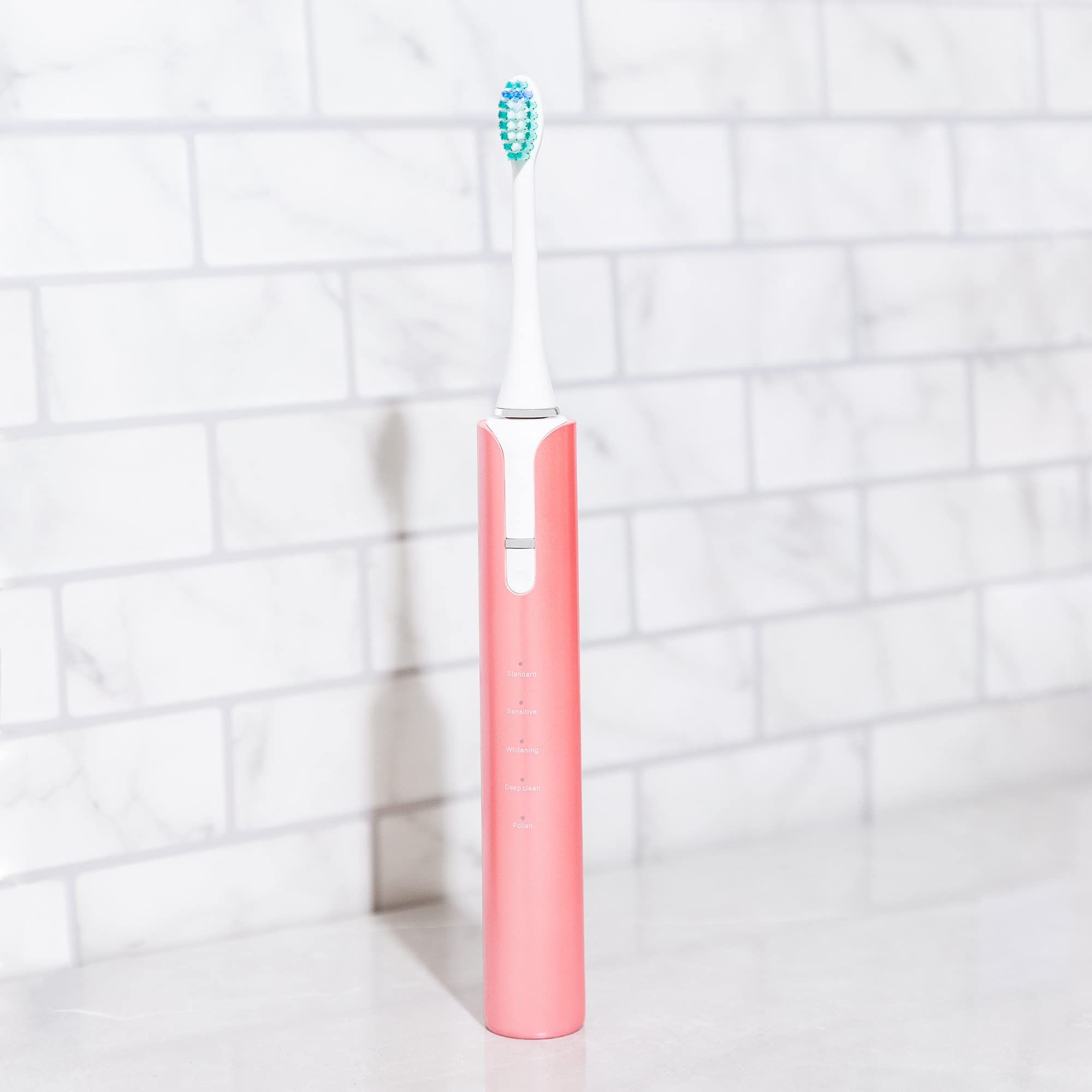 Soniclean Lux Sonic Toothbrush for Adults in rose gold with six replacement heads and rechargeable automatic operation.