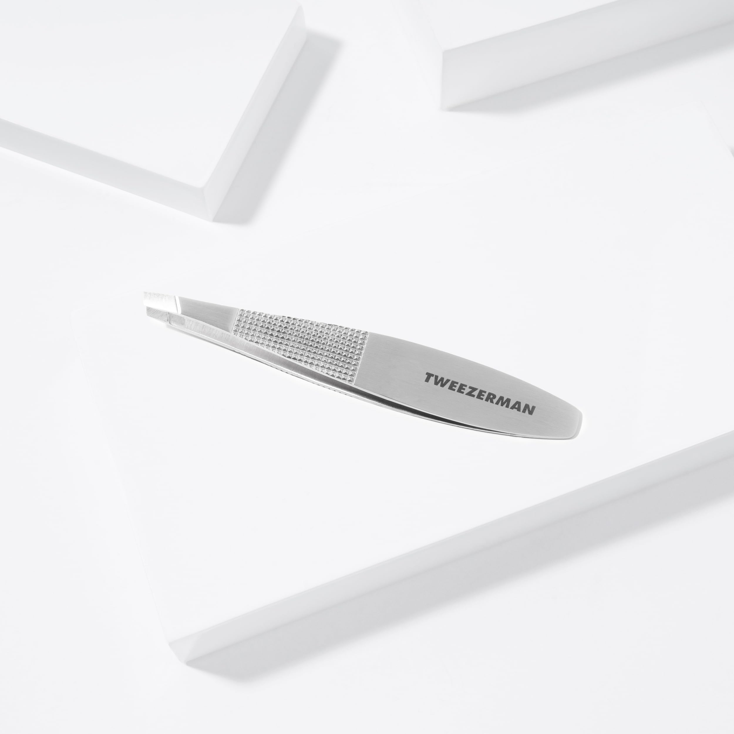Tweezerman Wide Grip Slant Tweezer made of stainless steel with ergonomic wide grip for precise eyebrow shaping.