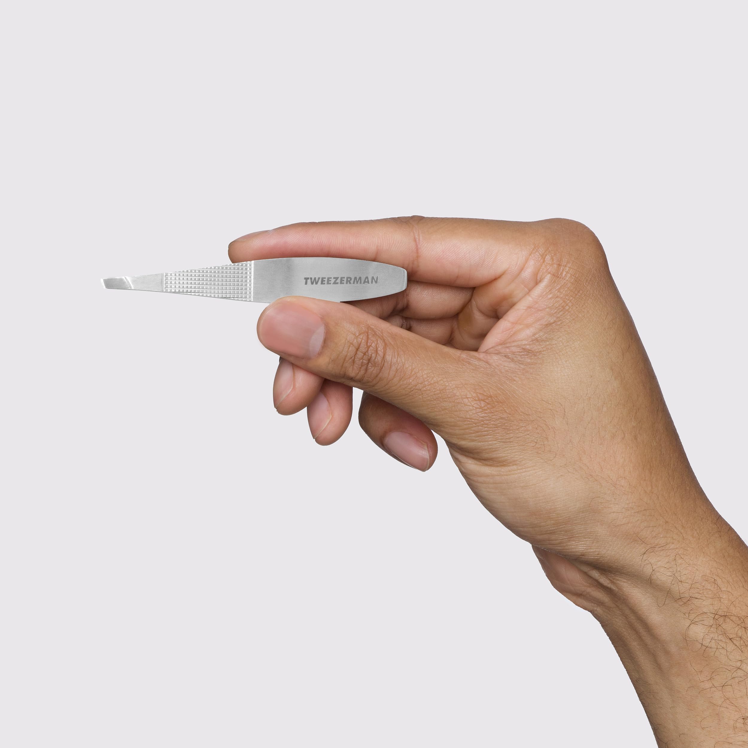 Tweezerman wide grip slant tweezer made of stainless steel, with precision tips for brow and lash grooming.