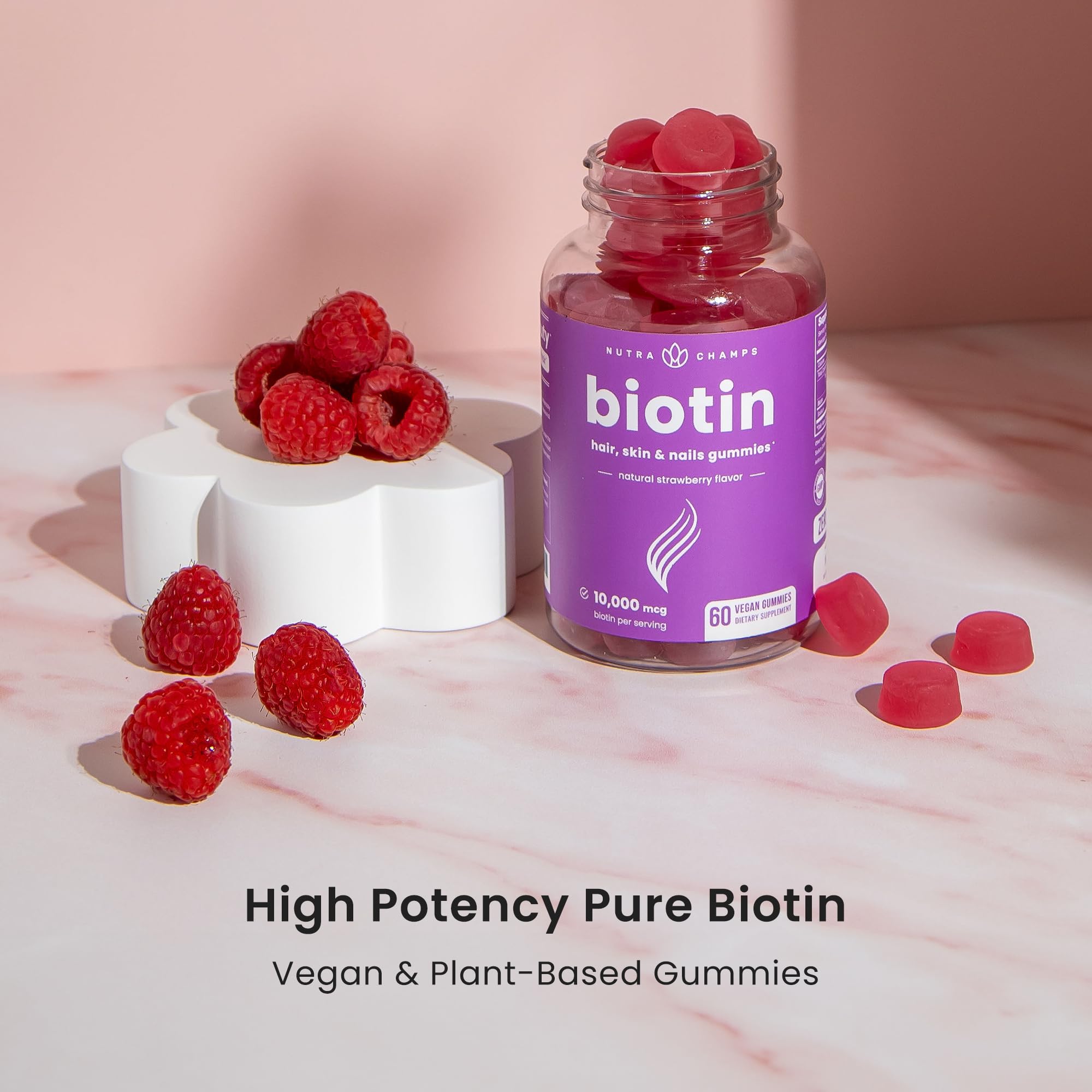 NutraChamps biotin gummies for hair, skin, and nails, showing two pectin-based vegan vitamin bottles with colorful gummies inside.