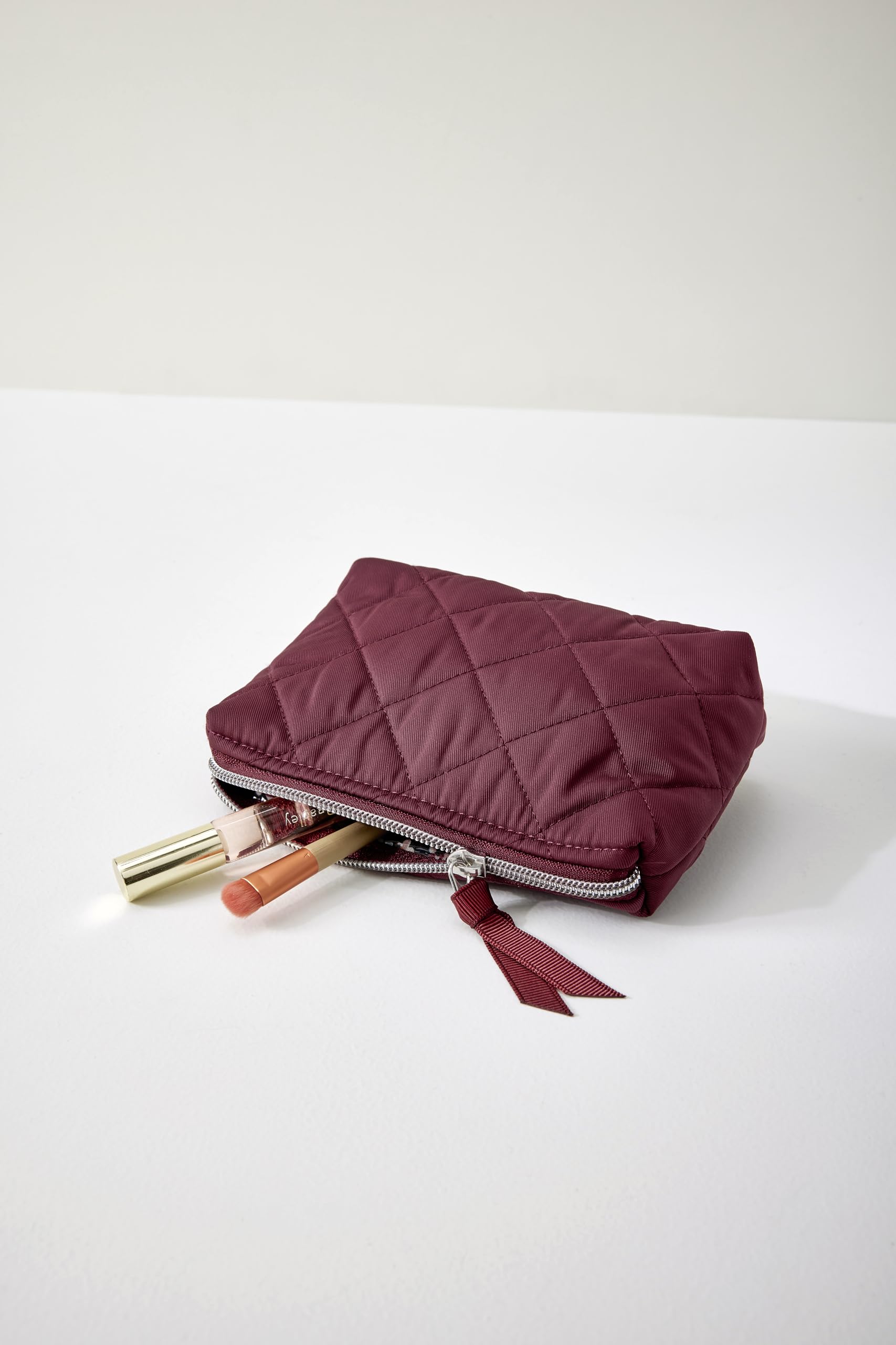 Vera Bradley Performance Twill cosmetic makeup organizer bag in raisin with multiple compartments and a zippered closure.
