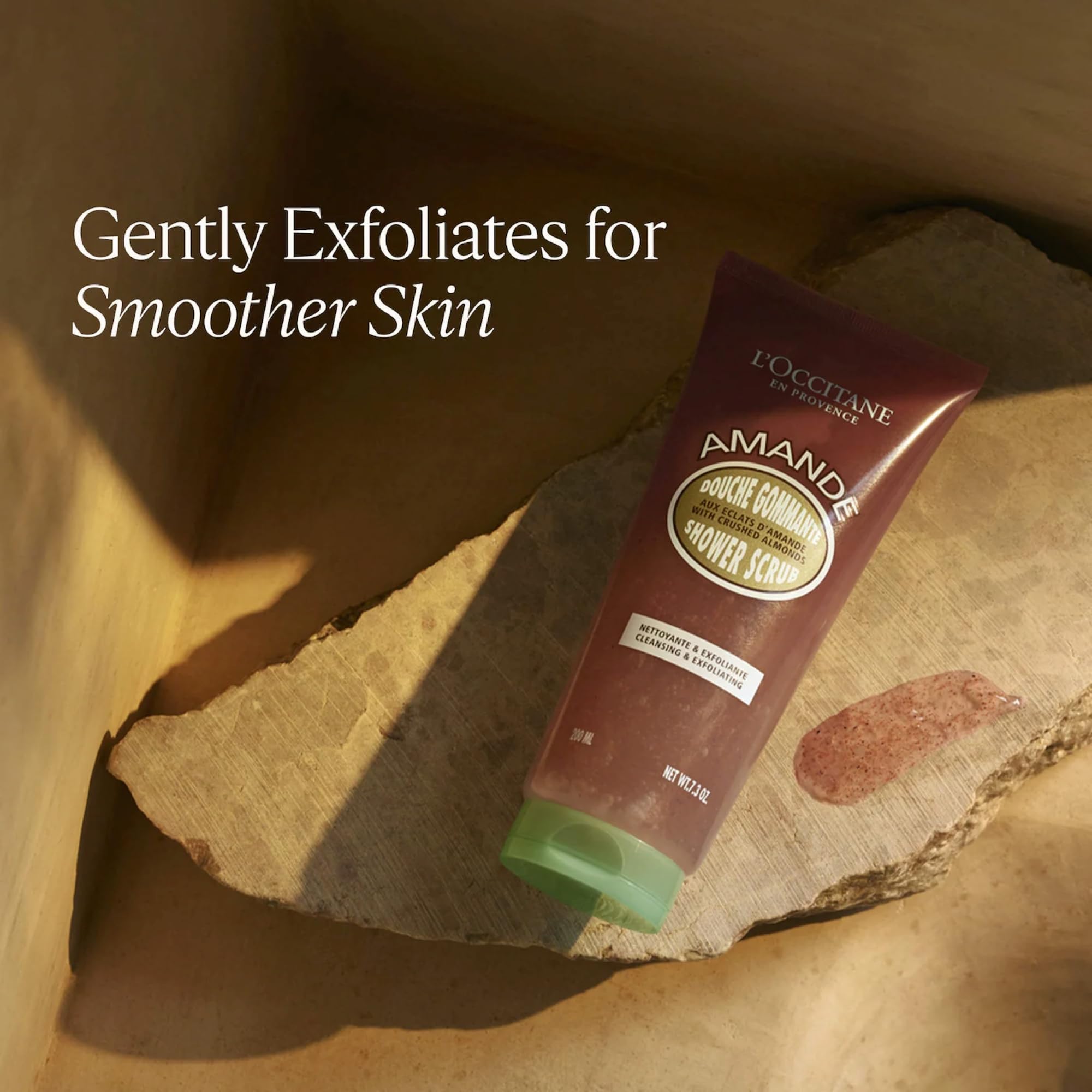 L'Occitane Almond Shower Scrub 2-in-1 exfoliating body wash with creamy texture and almond ingredients, in a white bottle.